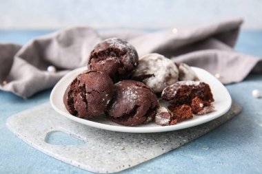 Mavi arka planda bir tabak çikolatalı kek.