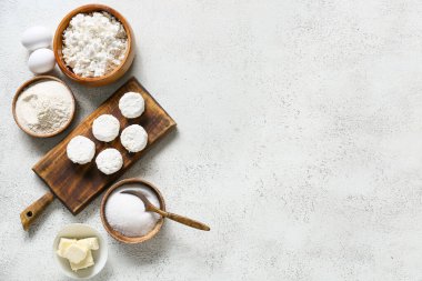 Pişmemiş süzme peynirli krep ve beyaz arka planda malzemelerle ahşap tahta tahta.