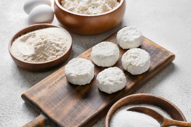 Pişmemiş süzme peynirli krep ve beyaz arka planda malzemelerle ahşap tahta tahta.