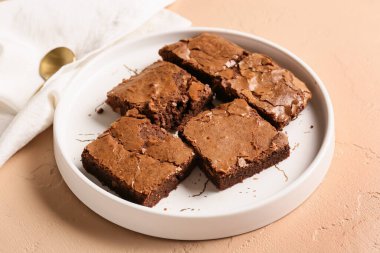 Bej arkaplanlı lezzetli çikolatalı browni tabağı.