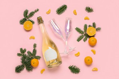Pembe arka planda şampanya, bardak, mandalina ve köknar dallarıyla kompozisyon