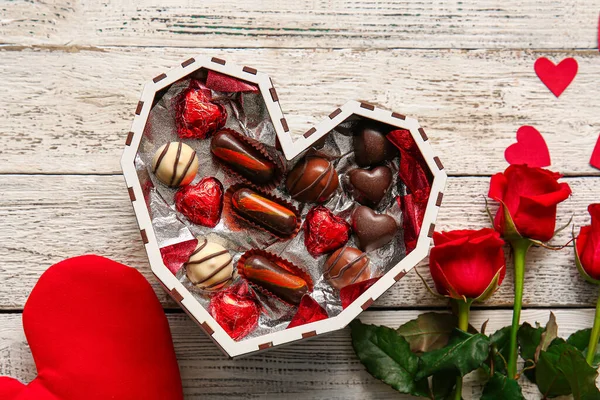 Herzförmige Schachtel Mit Leckeren Schokoladenbonbons Und Rosen Auf Weißem Holzhintergrund — Stockfoto