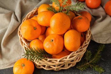 Siyah arka planda mandallı ve köknar dallı bir sepet.