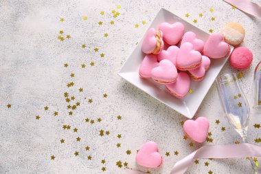 Lezzetli kalp şeklinde badem kurabiyesi ve açık arkaplanda cam tabağı.