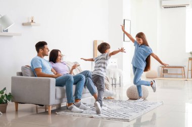 Mutlu ebeveynler ve evde dans eden çocukları.