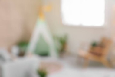 Oyun çadırı ve kanepesi olan çocuk odası bulanık görünüyor.