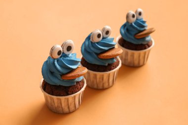 Cadılar Bayramı kutlaması için renkli arka planda lezzetli komik kekler.