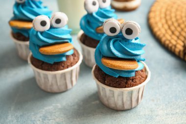 Cadılar Bayramı kutlamaları için renkli arka planda lezzetli komik kekler, yakın plan.