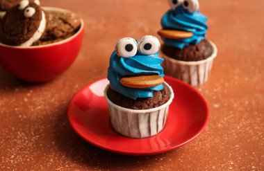 Cadılar Bayramı kutlaması için renkli arka planda lezzetli komik kek tabağı, yakın plan.