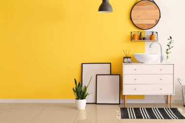 Çekmeceleri, lavabosu ve aynası olan şık bir banyo.