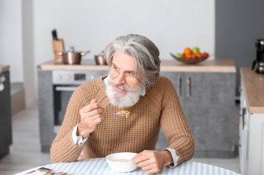 Son sınıf öğrencisi mutfakta kahvaltı yapıyor.