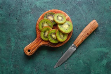 Tahta tahta tahta, yeşil arka planda taze kivi dilimleri.