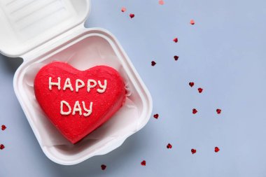 Gri arka planda lezzetli bento keki olan plastik beslenme çantası.