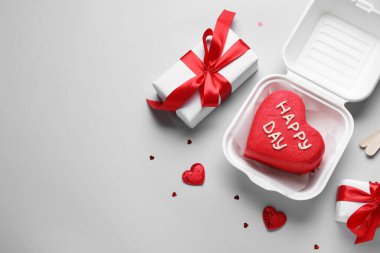 Lezzetli bento kekli plastik beslenme çantası ve gri arka planda hediyeler.