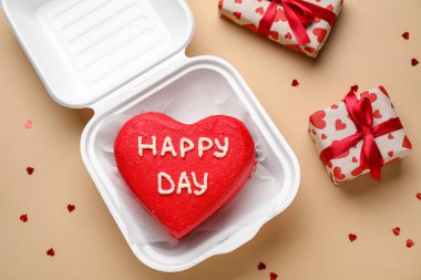 Lezzetli bento keki ve bej arka planda hediyeler içeren plastik beslenme çantası.