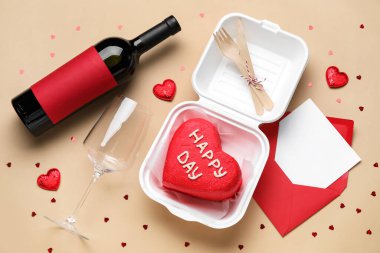 Lezzetli bento keki, bir şişe şarap ve bej arkaplanlı zarf.