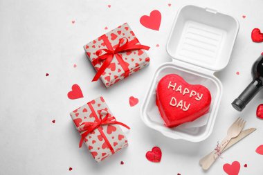 Lezzetli bento keki, bir şişe şarap ve açık arkaplanda hediyeler.