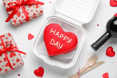 Lezzetli bento keki, bir şişe şarap ve açık arkaplanda hediyeler.