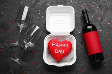 Lezzetli bento kekli kompozisyon, koyu arkaplanda bir şişe şarap ve bardak.