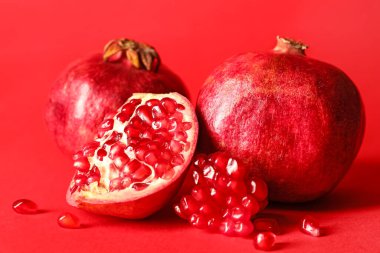 Kırmızı zemin üzerinde olgun lezzetli nar.