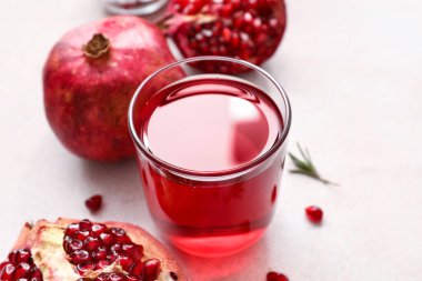 Bir bardak lezzetli nar suyu ve beyaz arka planda taze meyveler.