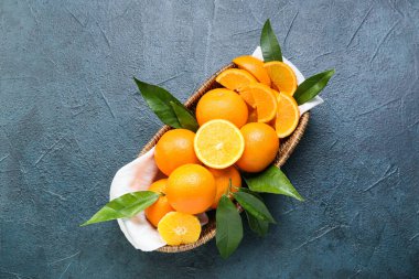 Siyah arka planda taze sulu portakallı sepet.