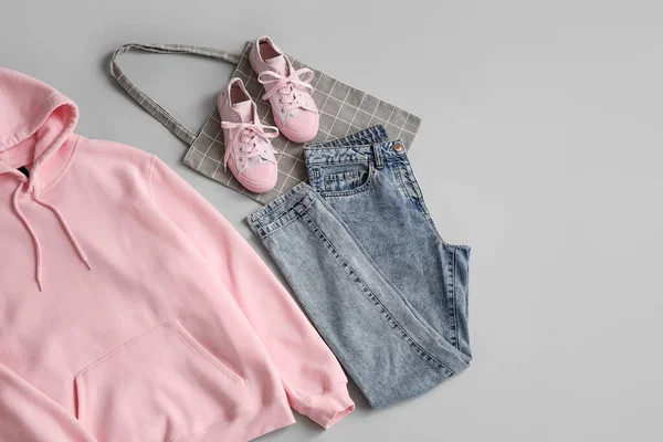 Roze Hoodie Met Jeans Sneakers Boodschappentas Grijze Achtergrond — Stockfoto