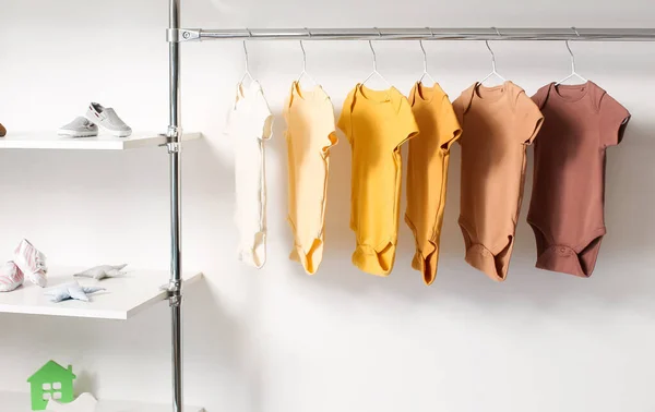 Bebek Kıyafetleri Odanın Işık Duvarının Yanında Asılı — Stok fotoğraf
