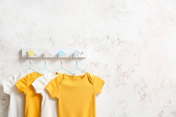 Different Baby Bodysuits Hanging Light Wall — Stock Photo, Image
