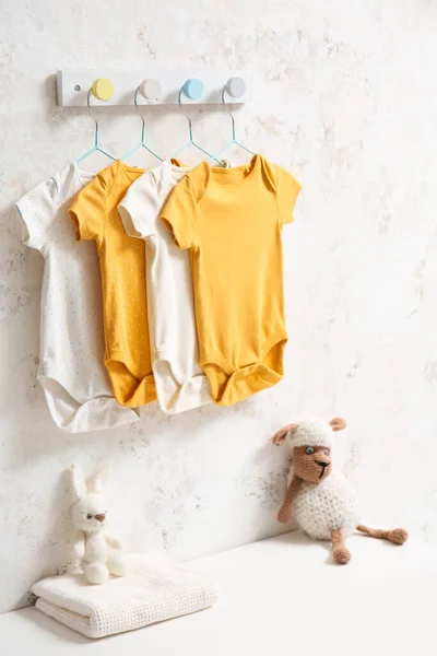 Different Baby Bodysuits Hanging Light Wall — Stock Photo, Image