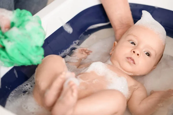 母親は赤ん坊を家でスポンジで洗い 閉じます — ストック写真