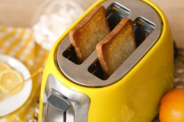 Mutfakta ekmek dilimleri olan sarı tost makinesi, yakın plan.