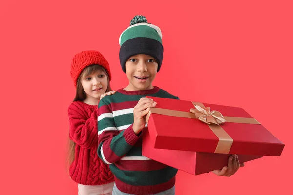 Niedliche Kleine Kinder Winterpullovern Und Mit Geschenk Auf Farbigem Hintergrund — Stockfoto