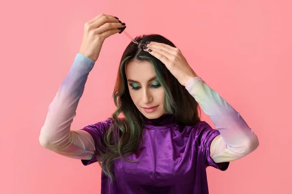 Молода Жінка Використовує Сироватку Лікування Випадіння Волосся Кольоровому Фоні — стокове фото