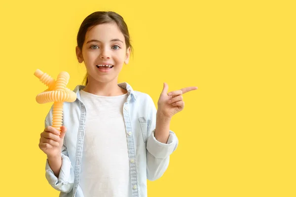 Little Girl Pop Tube Pointing Something Yellow Background — Stock Photo, Image