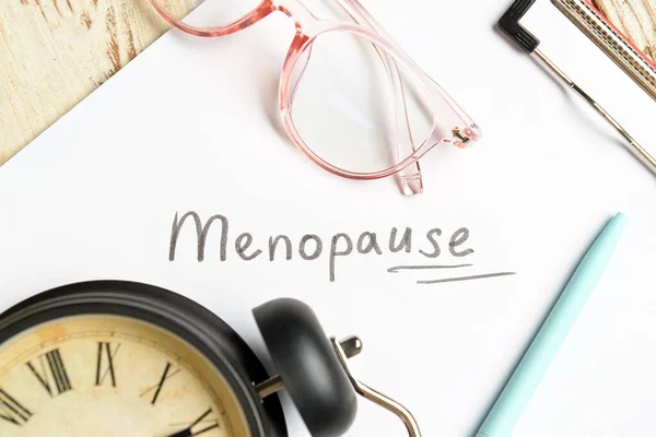 Clipboard Word Menopause Eyeglasses Alarm Clock Light Wooden Background Closeup — Stock Photo, Image