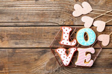 Kurabiyelerden yapılmış sevgi sözcüğüyle ve tahta arka planda kalplerle