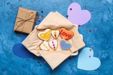 Kalp şeklinde kurabiyeler ve grunge arkaplanda hediyelerle dolu bir kase. Sevgililer Günü kutlaması