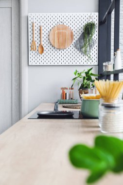 Ahşap mutfak gereçleri ve ışık duvarında asılı bitki örtüsü olan tahta tahta tahta tahta tahta.