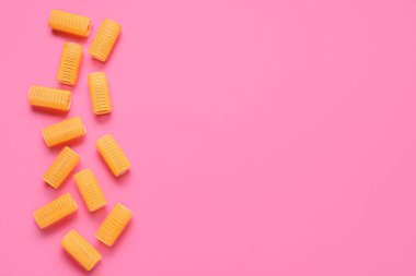 Pembe arka planda saç bigudileri