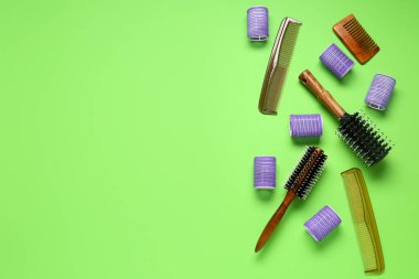 Yeşil arka planda saç bigudileri ve taraklar