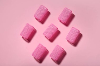 Pembe arka planda saç bigudileri