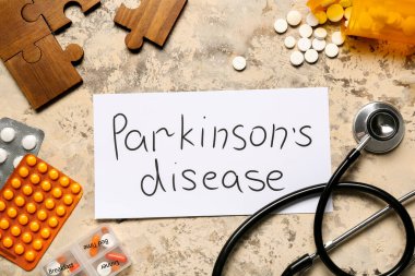 Parkinson Hastalığı, haplar, bulmaca parçaları ve grunge arka planda steteskop içeren kağıt kağıtlar.