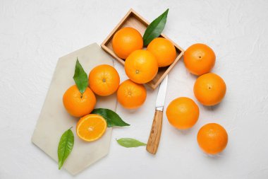 Tahta kutu ve beyaz arka planda taze sulu portakallar.