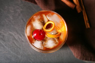 Bir bardak lezzetli siyah arka planda eski moda kokteyl.