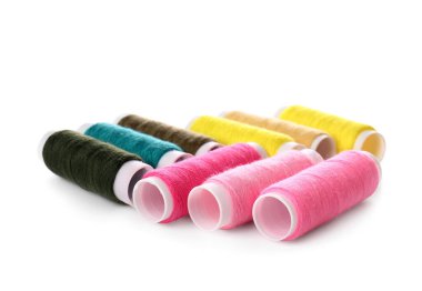 Beyaz arkaplanda farklı dikiş ipliği makaraları