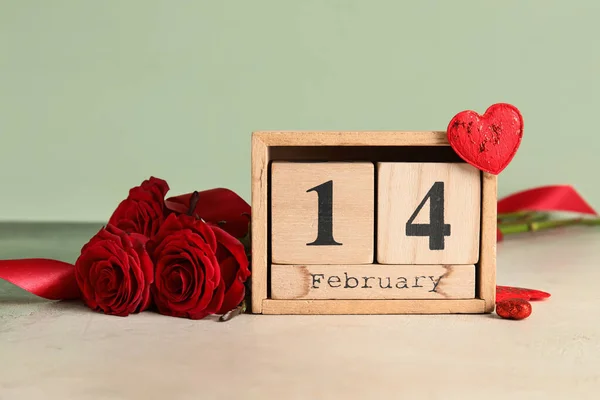カレンダーバレンタインデーとテーブルの上の赤いバラ — ストック写真