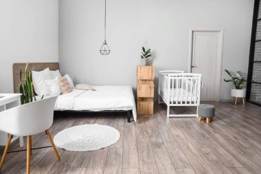 İçinde bebek beşiği olan modern aydınlık yatak odası.