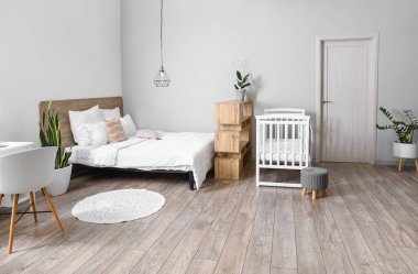 İçinde bebek beşiği olan modern aydınlık yatak odası.