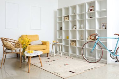 Bisikletli, koltuklu ve raf üniteli modern odanın içi